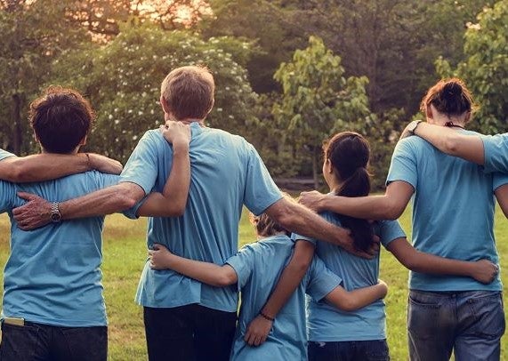 A group of kids and adults wearing blue shirts